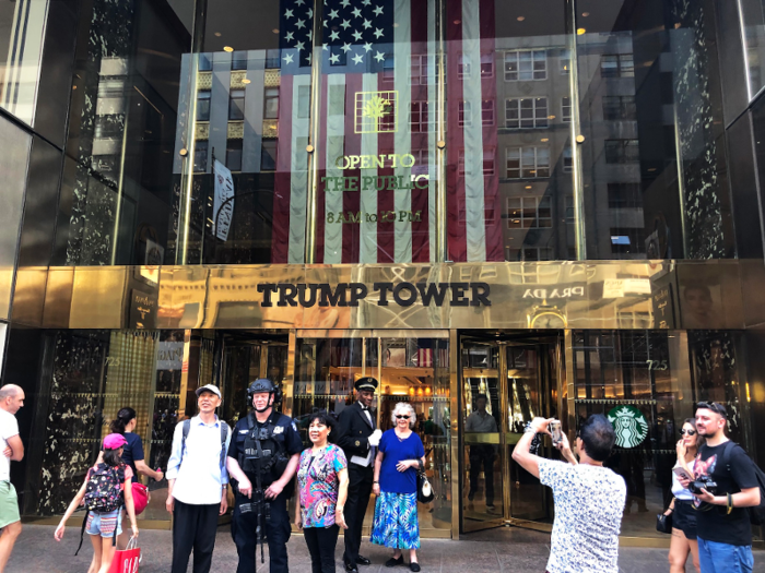 There were tourists taking photos with well-dressed doormen outside Trump Tower