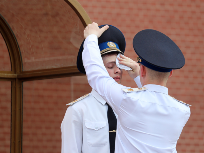 Like Britain, guards in Russia maintain their positions despite the heat. Here, one soldier wipes the sweat off the brow of another.