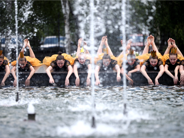 In Moscow, girls cool off by the fountain in front of Ostankino Tower.