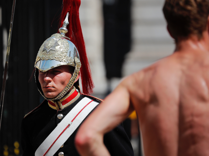 In the United Kingdom, a guard does his best to ignore the heat. It requires a jaw-clenching effort.