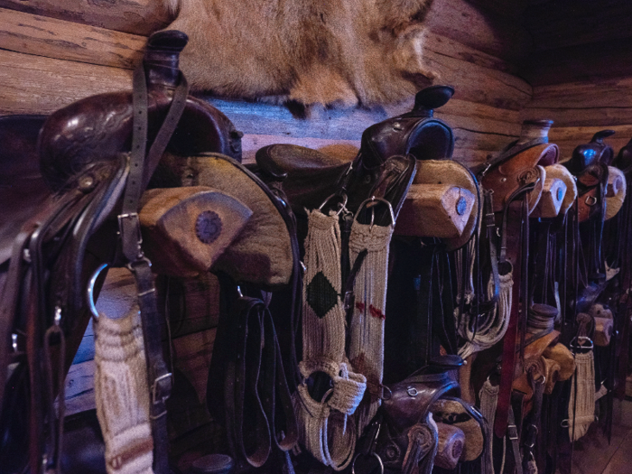 Inside the barn, rows and rows of saddles line the walls.