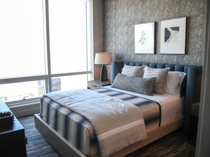 One of these bedrooms is decked out in blue and grey tones …