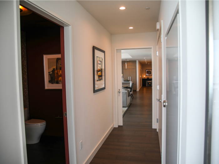 A hallway with a half bathroom leads to the other parts of the penthouse.