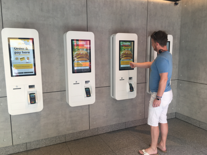 Walking inside, the first things in sight were the touchscreens along the wall. The interior was otherwise completely featureless — the walls were finished in dull gray, the floor was plain, and it reminded me a bit of walking into an oversize ATM vestibule.