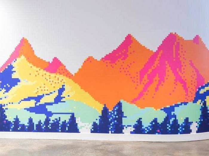 The office is covered in art, including this mural of mountains.