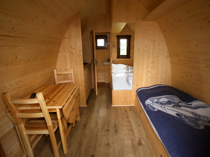 The heated pods include a kitchenette and fridge, table and chairs, a bathroom, a double bed and a pullout sofa bed.