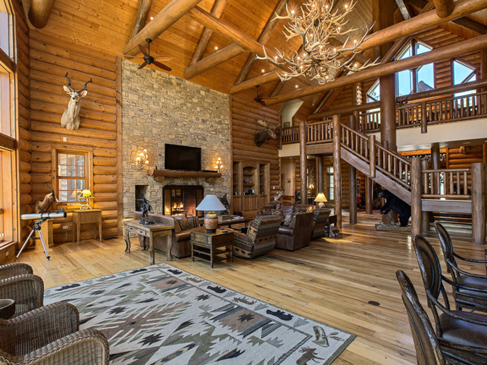 The living room, pictured below, is 2,000 square feet and has floor-to-ceiling windows and a custom-built elk antler chandelier.