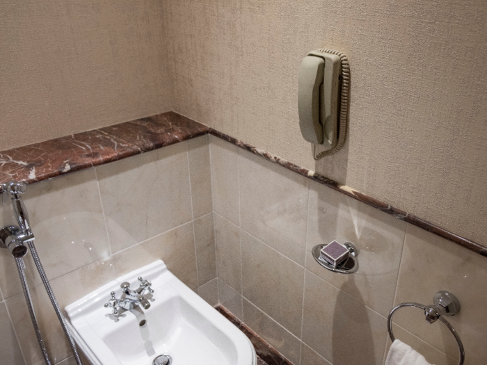 The bathroom includes a bidet with a telephone next to it, and another phone next to the bathtub.