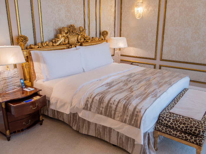 The king-size bed features an elaborate golden headboard.