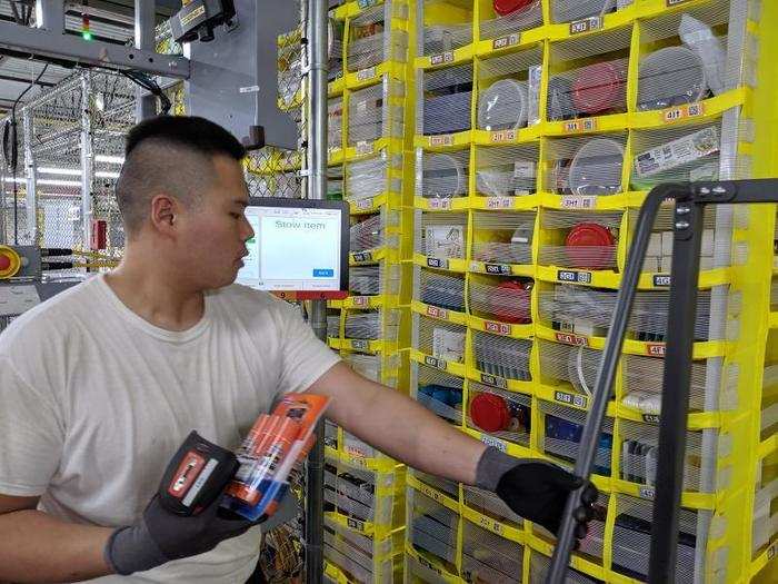 A Ricoh projector over each station literally shines guiding lights onto individual sections of the yellow storage bin.