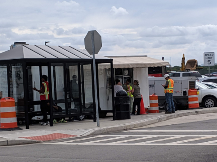 A food truck was serving lunch out in the parking lot, next to a bus stop where workers waited for a ride home.