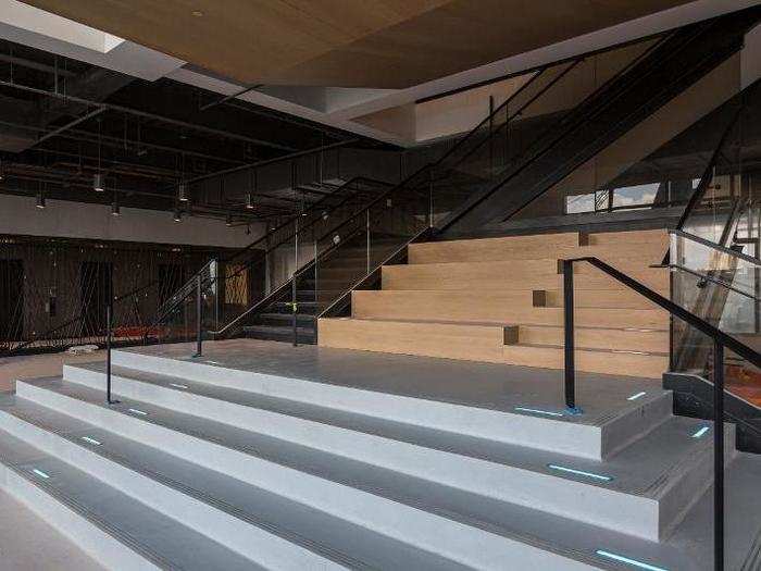 The first floor of the building features a large, open staircase leading to a second floor with a balcony. The first floor also includes a cafeteria which will be open to anyone with access to the Brooklyn Navy Yard.