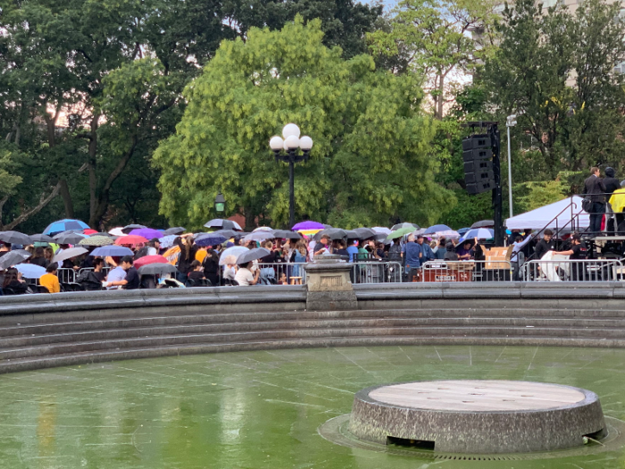 It briefly started to rain before the rally began, and scores of people pulled out their umbrellas.