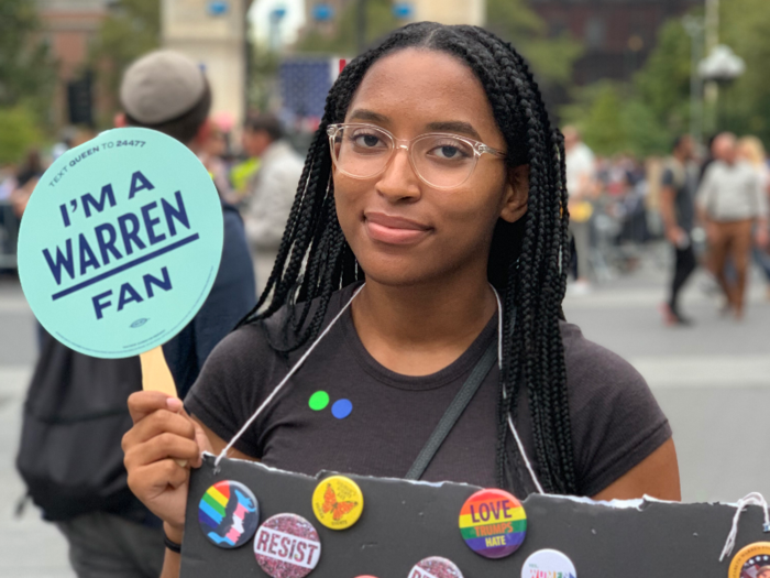 Mehdji Belizaire, a 19-year-old Warren volunteer, was busy handing out campaign buttons to rally goers. She says she