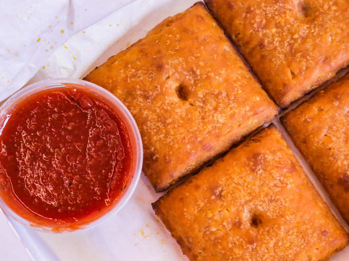 These giant Cheez-It shaped pastry pockets have a crispy outer shell and are filled with cheddar and sauce.