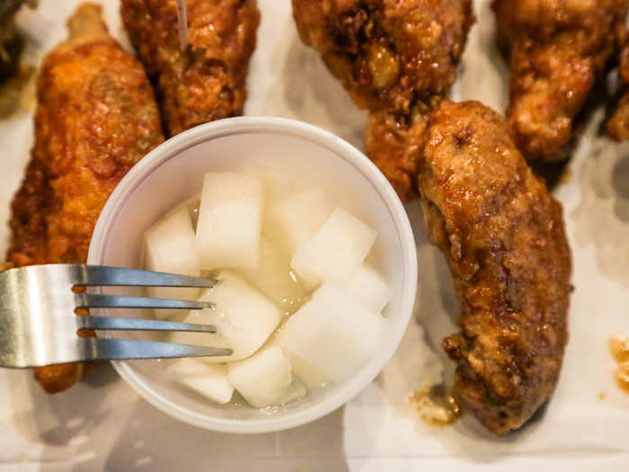 Instead of celery or carrot sticks, Bonchon gives you a side of pickled radish or coleslaw with your wings.