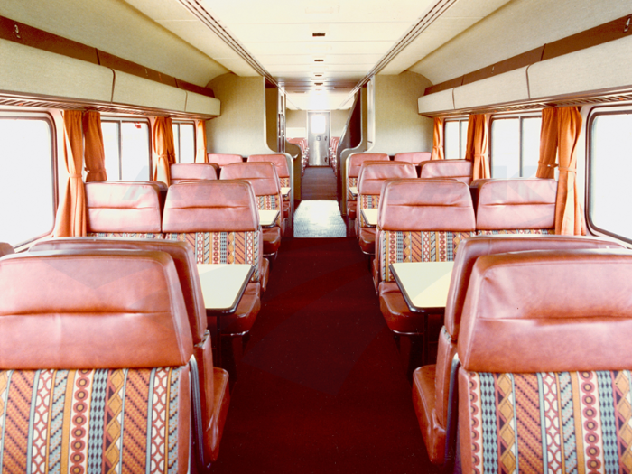 The dining car in this Superliner train had 18 tables, seated 72 passengers, and had a central serving area. The downstairs kitchen, the original shown two pictures prior, was converted to all-electric when this photo taken in the 1980s.