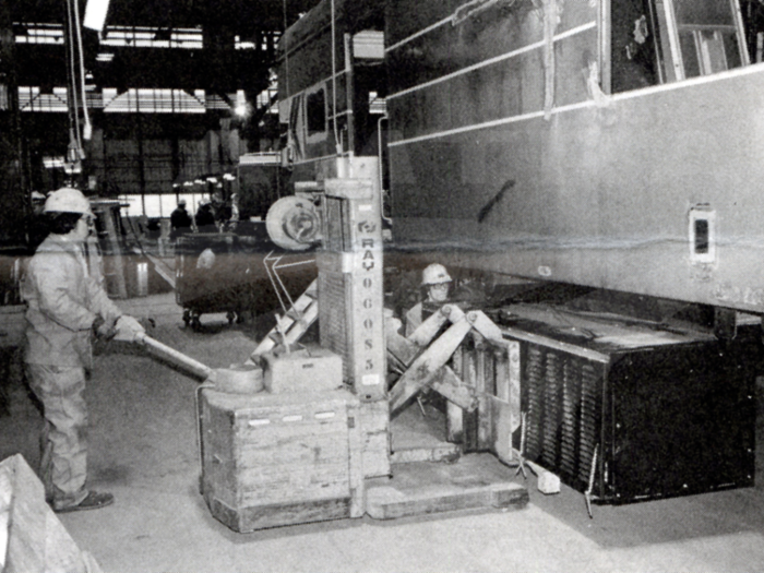 Welders were working to install a new air conditioning unit under a dining car in this photo taken in 1980.