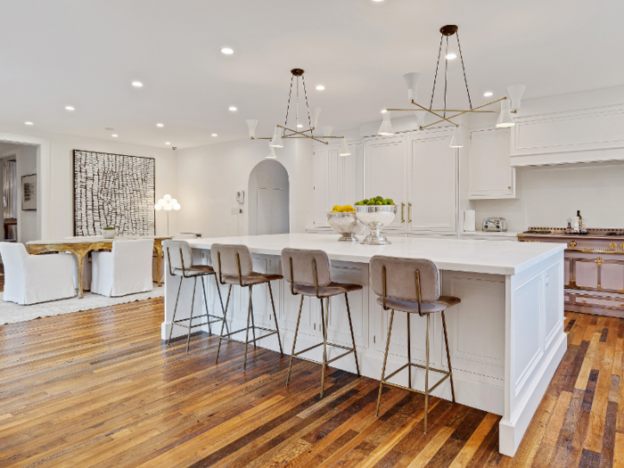 The kitchen has a contemporary appearance and features a large island with four bar stools.