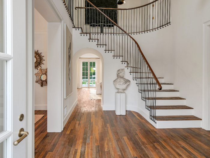 It opens up to wooden floors and an entryway staircase.