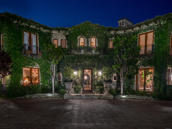 The Italian-style villa boasts an ivy-covered, 16,773-square-foot main house, a two-story guest house, and a variety of over-the-top amenities, including a home theater and an outdoor tennis court.