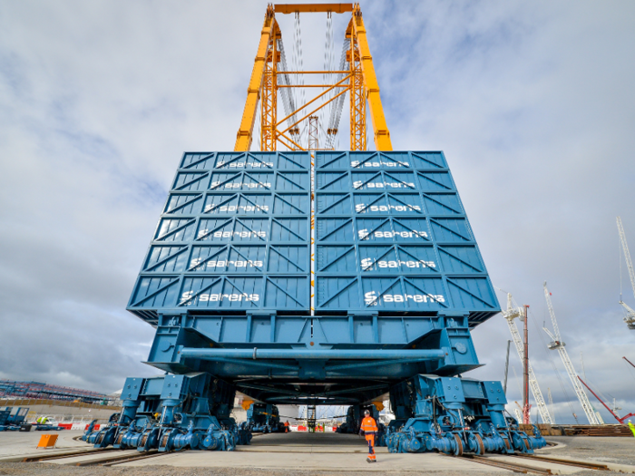 The crane is supported by 52 counterweight containers, each weighing 100 tons.