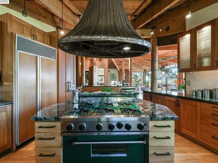 The kitchen incorporates wood, stone, and granite to fit into the natural landscape.