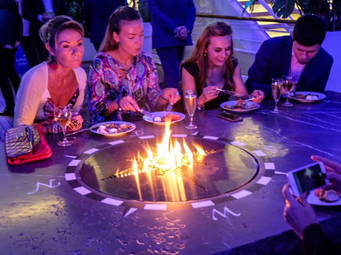 Many people were already eating, some seated around a large rectangular table with a flaming compass in the middle that I initially thought was some sort of DIY grill, but instead just seemed to be ... for fun?