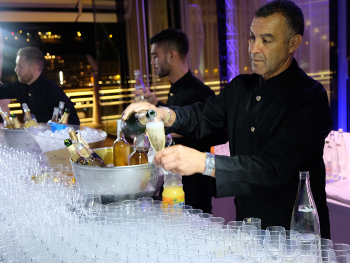 At an open bar, bartenders were serving Champagne, wine, and beer.