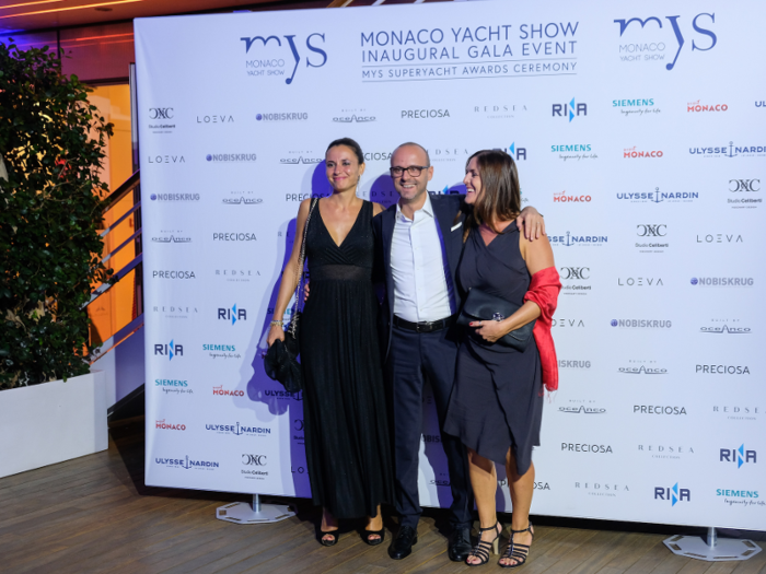 A Monaco Yacht Show photographer was taking photos of groups of friends in front of an official backdrop listing the show