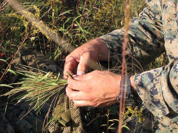 To "veg up," as the process is called, the snipers collect grasses and other vegetation and weave it into the their mesh covers.