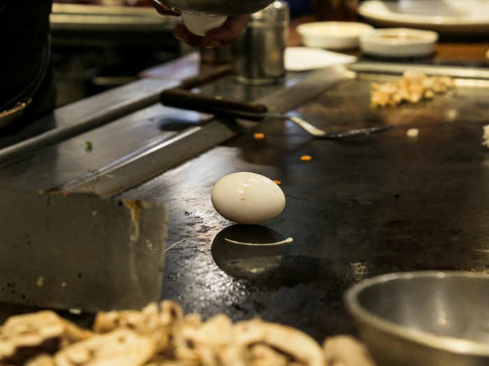 Chef Haque spun an egg onto the grill top, then his spatula, before flipping it into the air and catching it again.