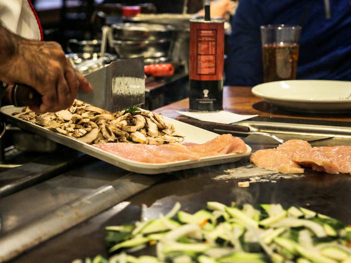 Chef Haque swept veggies, chicken, and mushrooms onto the hot metal.