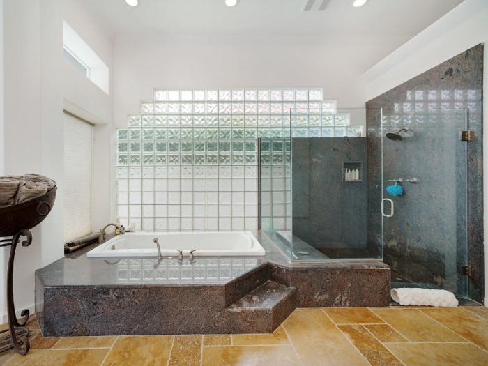 The private ensuite bathroom has an enormous shower and a spa-like soaking tub. There are two other bathrooms.