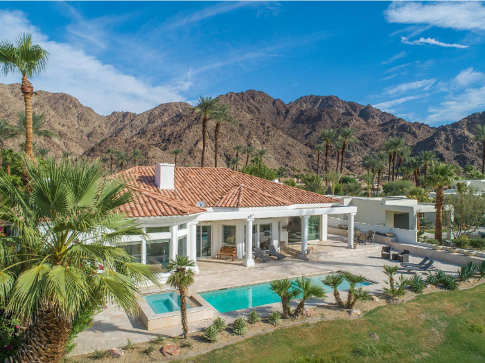 The home is separated from the fairway by light landscaping.