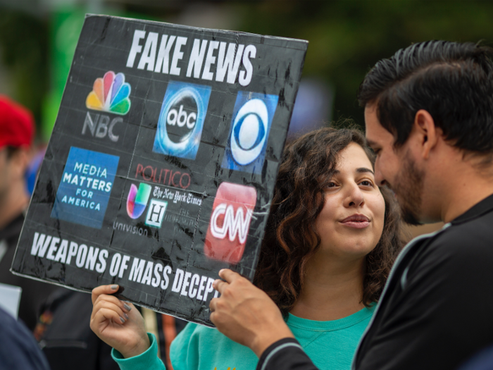 Trump supporters also use placards to remind people which "Fake News" media companies they don