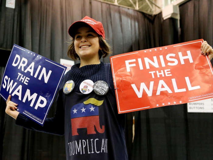 Here, a young supporter wears a "Trumplican" sweater, and reminds Trump of his two tasks — draining Washington, or "the swamp," and finishing his wall between the US and Mexico.