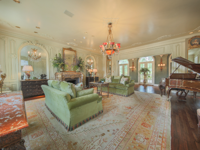 The living room makes use of soft pastel colors and Rococo-styled marble dressers.