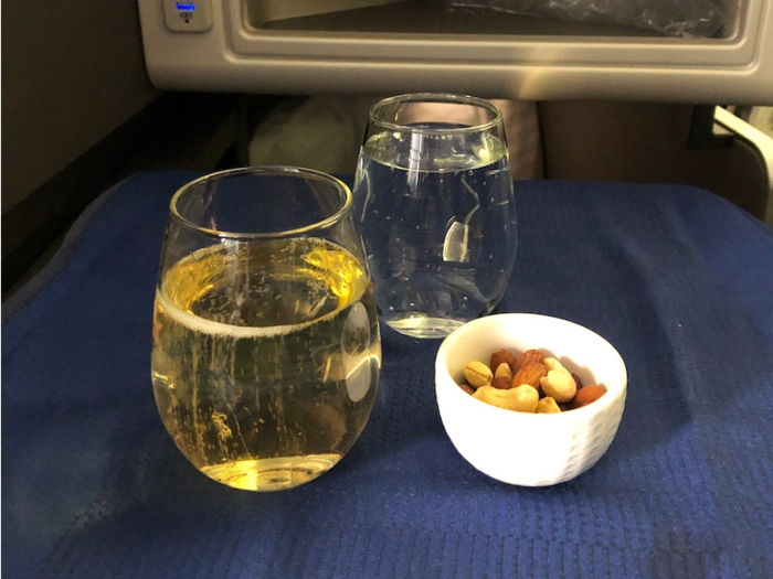 Not too long into the flight, the meal service began with an offering of warmed nuts and a beverage. I chose Champagne — living my best, upgraded life over here!