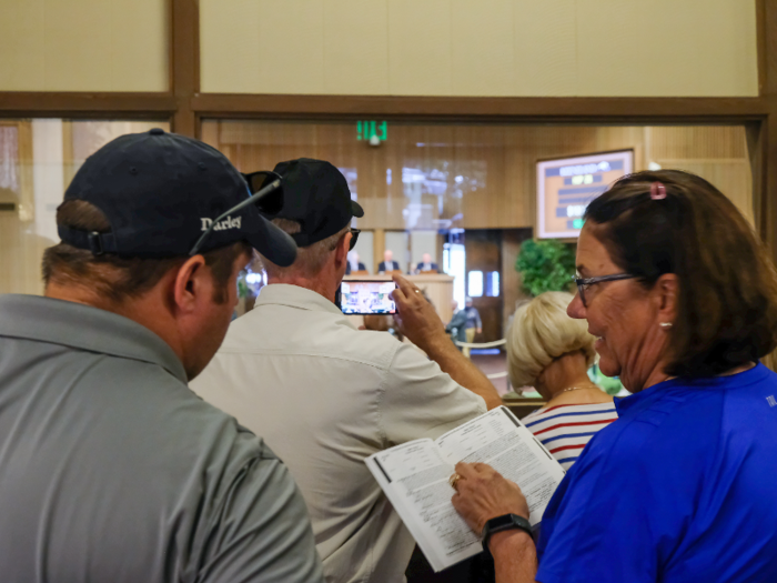 The seats in the sales arena are reserved for prospective buyers, but behind a glass wall encircling the back of the arena, many observers sat on benches and watched the sale from a distance.