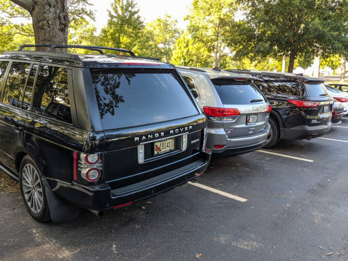 The massive parking lot was already filling up with cars, many of them luxury vehicles like Range Rovers and Mercedes.