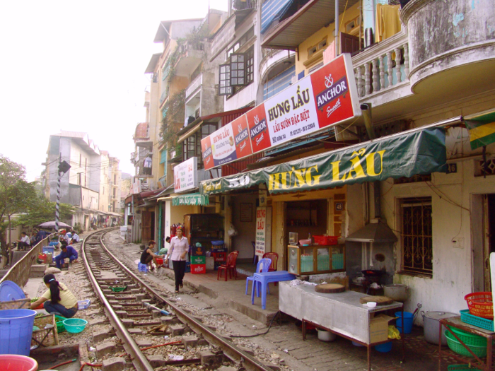 Residential homes, vendors, and cafes line the side of the streets.