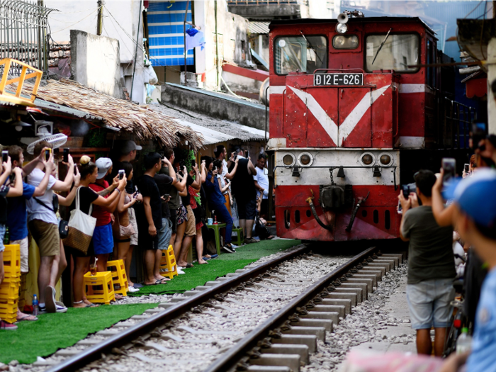 They also line up dangerously on the side of the tracks, waiting to snag a photo of the passing trains.