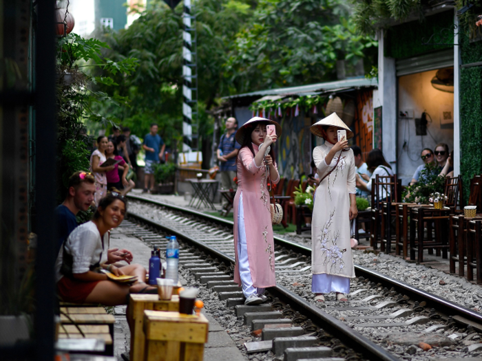 Tourists have been taking photos of themselves standing or sitting on the train tracks.