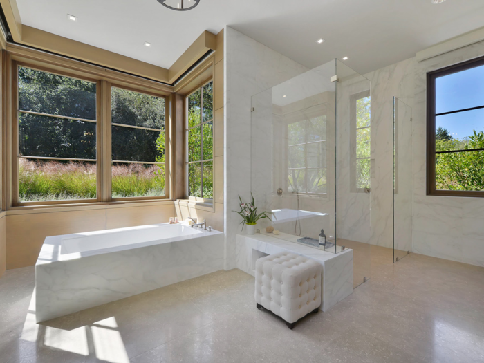 The main floor master bathroom includes a marble soaking tub with views of the backyard ...