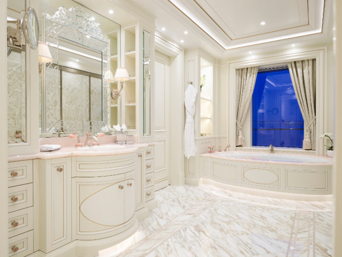 The bathroom is decked out in marble and includes a large soaking tub.