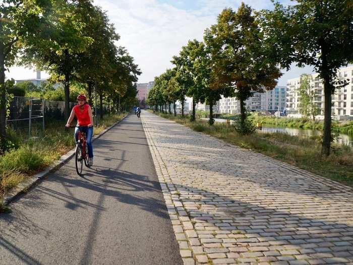 The lane continues with a clear demarcation between pedestrian walkway (cobblestones) and bike lane (paved path).