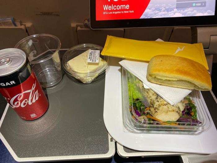 Flight attendants came through with lunch about an hour after we left the ground. I was feeling pretty exhausted and scattered by this point, and forgot to take a picture of the menu. There were a few choices, including the herbed chicken salad I ordered, which came with a piece of garlic bread and a slick of cheesecake for dessert.