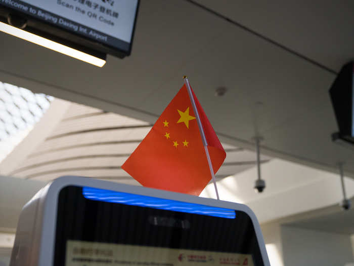 The futuristic new airport had hundreds of these self-check-in kiosks equipped with facial-recognition technology and adorned with a Chinese flag.