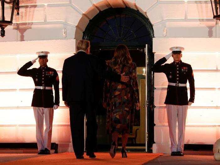 The president and the first lady make their way inside the White House after handing out their candy.